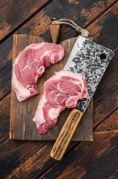 Raw lamb chump chops with bone on rustic wooden board, fresh sirloin saddle.. Stock Photos