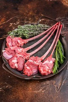Raw lamb cutlets on bone in cast iron skillet with herbs warm dark backgrou.. Stock Photos