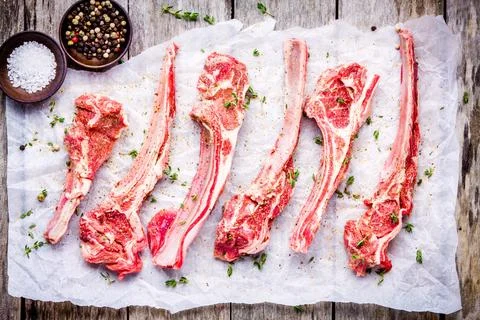 Raw lamb meat ribs with thyme on paper Stock Photos