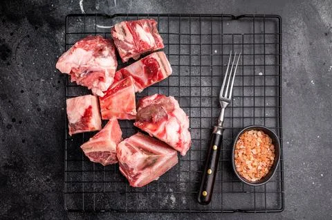Raw lamb mutton meat and bones for stew or goulash. black background. top vie Stock Photos