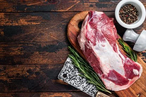 Raw lamb mutton shoulder meat on the bone on a wooden butcher cutting board with Stock Photos