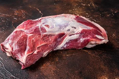 Raw lamb mutton shoulder meat on the bone. Dark background. Top view Stock Photos