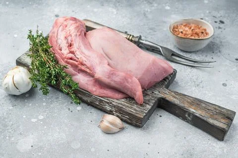 Raw lamb mutton tongue with thyme garlic and salt on wooden board over ston.. Stock Photos
