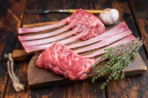 Raw lamb rack ribs with bone on rustic wooden board dark background top vie.. Stock Photos