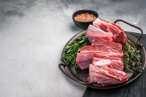 Raw lamb Riblets, fresh mutton meat with rib bone. grey background. top view Stock Photos
