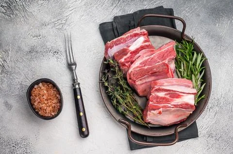 Raw lamb Riblets, fresh mutton meat with rib bone. grey background. top view Stock Photos