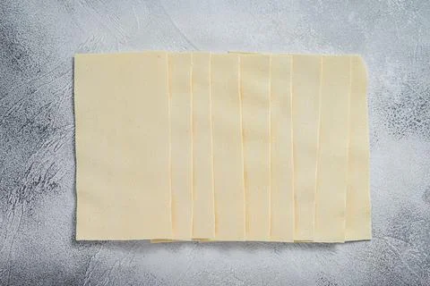 Raw lasagna sheets stack on a kitchen table. White background. Top view 写真素材