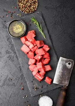 Raw lean diced casserole beef pork steak on chopping board Stock Photos