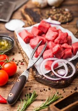 Raw lean diced casserole beef pork steak with vintage meat hatchet and knife Stock Photos