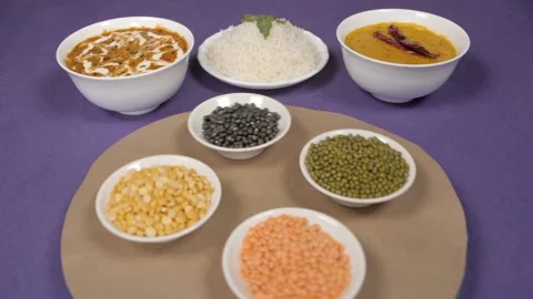Raw lentils / Dal kept on a rotating table with a cooked meal of Dal-Chawal Stock Footage 145248593