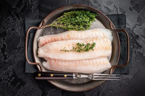 Raw Loin cod fish fillets ready for cooking whitefish in stell tray. black .. Stock Photos
