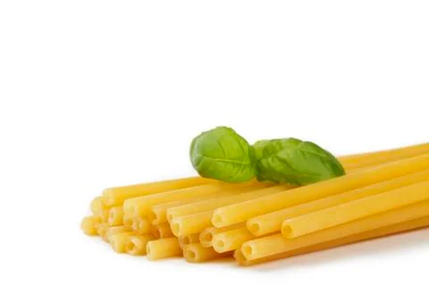 Raw macaroni with basil Stock Photos