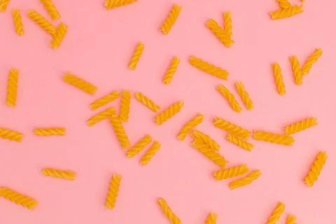 Raw macaroni on pink background Stock Photos