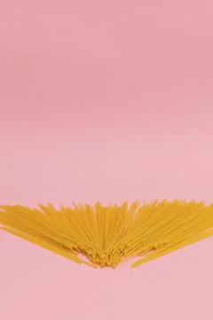 Raw macaroni on pink background Stock Photos
