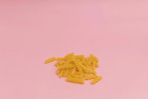 Raw macaroni on pink background Stock Photos