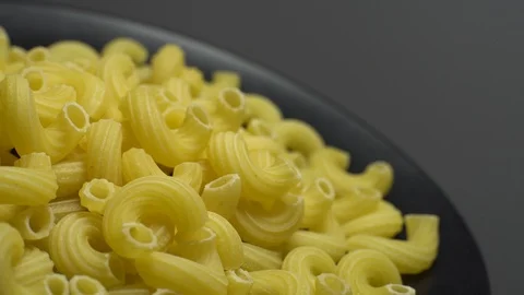 Raw macaroni in rotation. Elbow macaroni. Macaroni rigati close up. Stock Footage 101667566