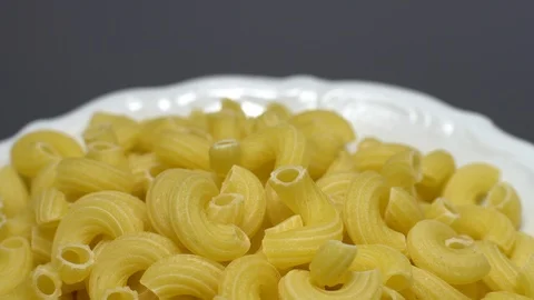 Raw macaroni in rotation. Elbow macaroni. Macaroni rigati close up. Stock Footage 101746794