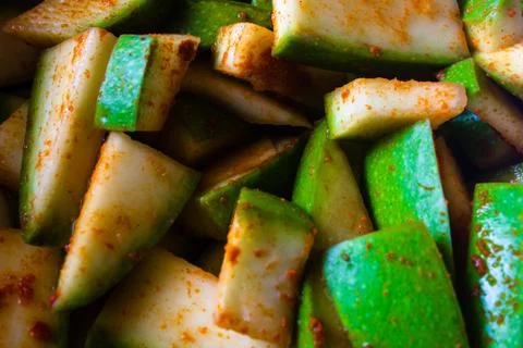 Raw mango cut into small pieces mixed with salt and red chili pepper Stock Photos