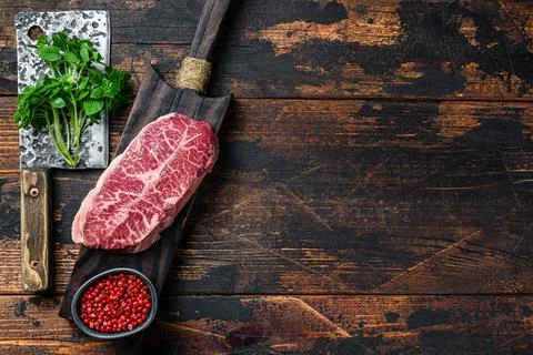 Raw marble beef meat steak. Dark wooden background. Top view. Copy space Stock Photos
