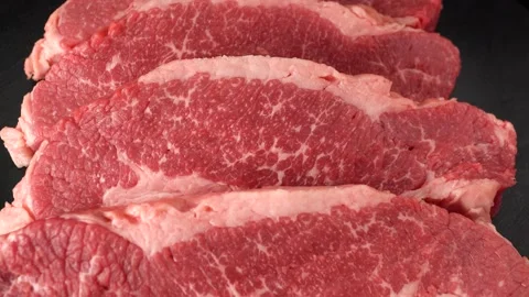 Raw marbled beef steaks close up on black background Stock Footage 147022458