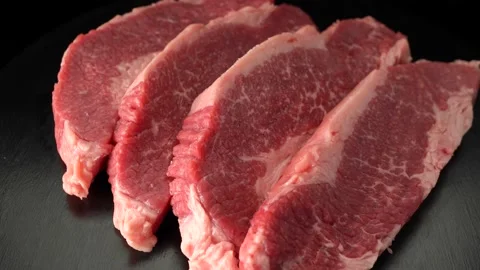 Raw marbled beef steaks close up on black background Stock Footage 147121196