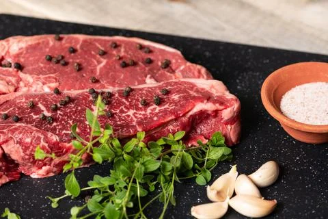 Raw Marbled Beef Steaks with Herbs Stock Photos