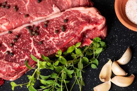 Raw Marbled Beef Steaks with Herbs Stock Photos