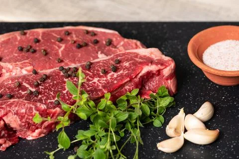 Raw Marbled Beef Steaks with Herbs Stock Photos