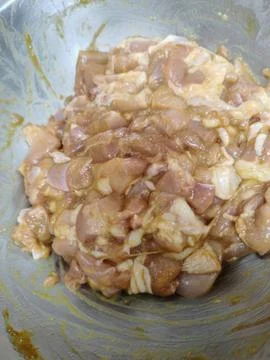 Raw Marinated Chicken Chunks in a Stainless Steel Mixing Bowl for Meal Prep Stock Photos