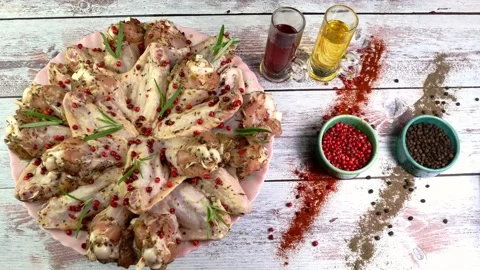 Raw marinated chicken wings sprinkled with spices, red peppercorns and rosemary Stock Footage 196868997