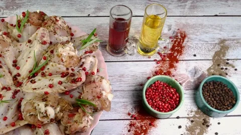 Raw marinated chicken wings sprinkled with spices, red peppercorns and rosemary Stock Footage 196869755