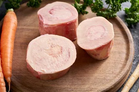 Raw marrow bones and vegetables - ingredients to make bone broth or soup Foto stock