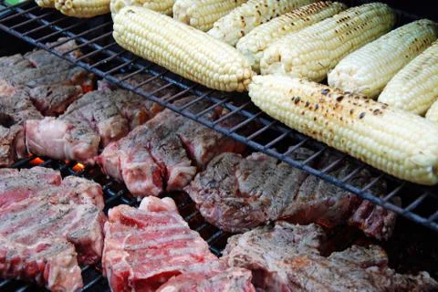 Raw meat and corn prepared on the grill Stock Photos