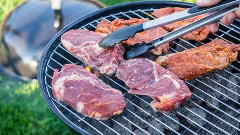 Raw meat on a barbeque grill Stock Photos