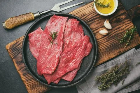 Raw meat beef on cast iron plate. toned, top view Stock Photos