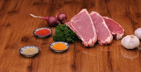 Raw meat on the board with spices Фото