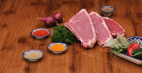 Raw meat on the board with spices Stock Photos
