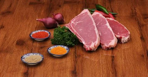 Raw meat on the board with spices Stock Photos