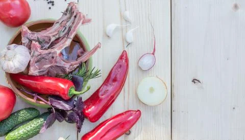 Raw meat on a bone prepared for frying, in a bowl with fresh paprika, garlic Stock Photos