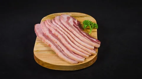 Raw meat close up rotation. Sliced bacon served with herbs on wooden board Stock Footage 48597899
