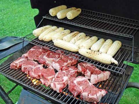 Raw meat with a corn on the grill Stock Photos