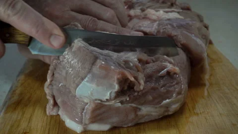 Raw meat is cut with a knife in slow motion Stock Footage 150157091