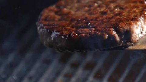 Raw meat cutlet falls into the pan. Stock footage. Burger Patty falls on the pan Stock Footage 115774677
