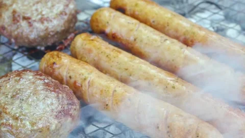 Raw meat on grill, BBQ cutlets and sausages in herb and spices fried on coals Stock Footage 155706000