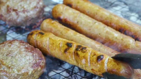 Raw meat on grill, BBQ cutlets and sausages in herb and spices fried on coals Stock Footage 157114750