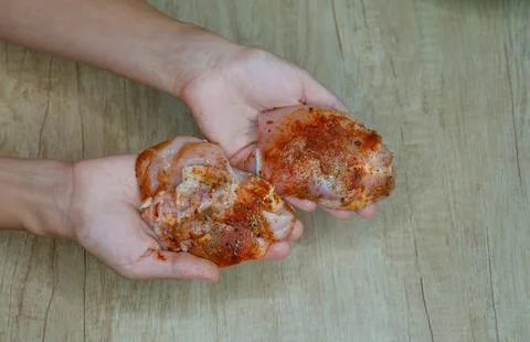 Raw meat in hands with spices in Stock Photos