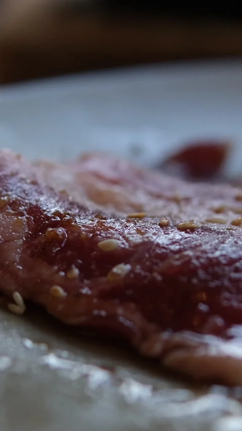 Raw meat marinated by the chef. The chef sprinkles the steak with spices Stock Footage 312445879