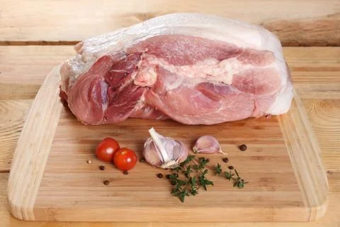 Raw meat, pork, ham on the bone, on a wooden board 写真素材