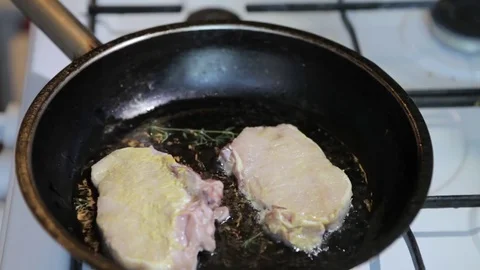 Raw meat is put in a frying pan. Steak fry in a frying pan. Stock Footage 77708571