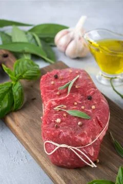 Raw meat. Raw beef steak on a cutting board with greens and spices. Foto stock